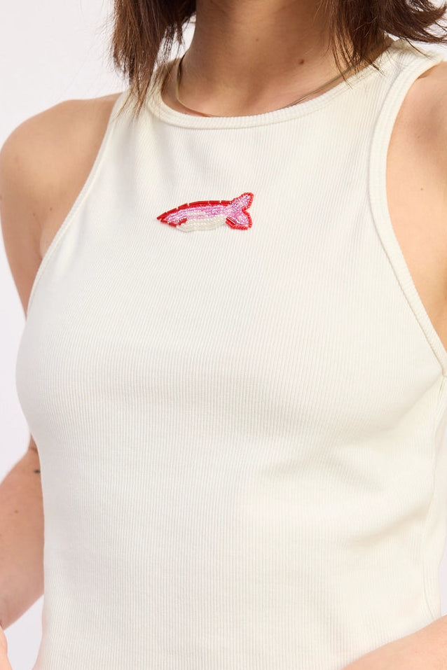 Person wearing a white tank top with a small red and pink beaded fish design on a plain background. Perfect for everyday cool girl outfits. Ribbed tank.